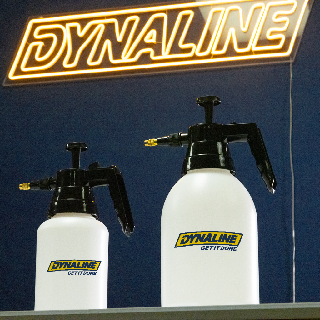 Two white pump sprayers displayed beneath a Dynaline sign