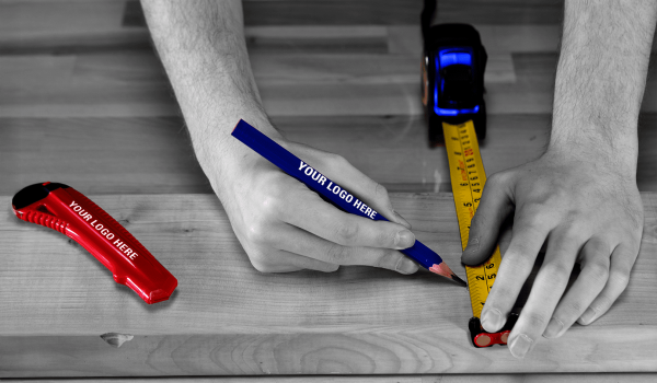 Hands marking measurement lines on wood with a blue carpenter pencil
